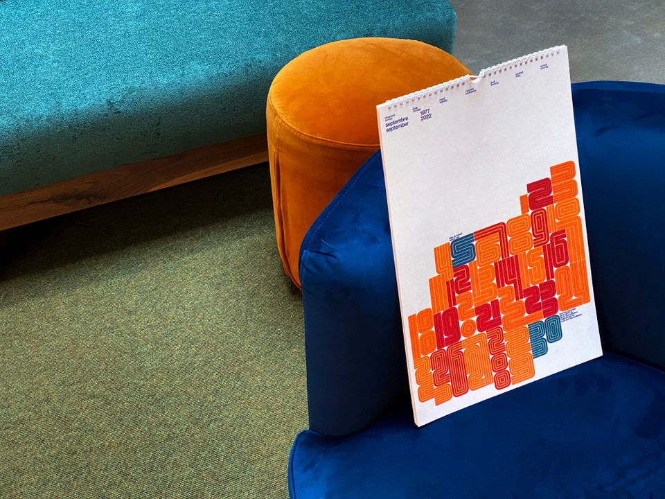 A red, blue and yellow modernist September 2022 calendar on a blue couch